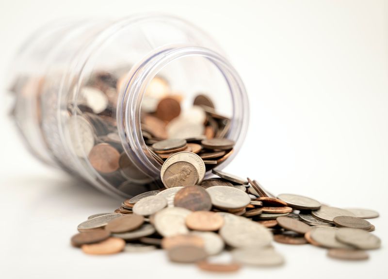 Money jar spilling coins.