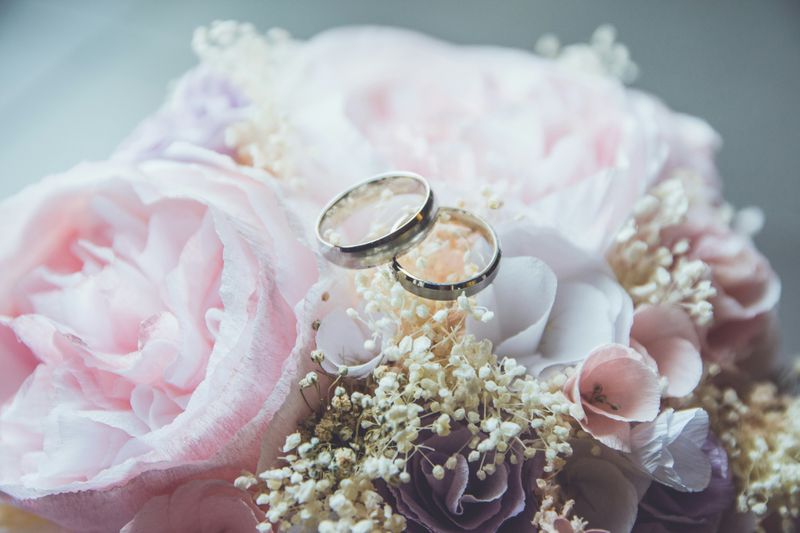 Two wedding rings on a bouquet of flowers.