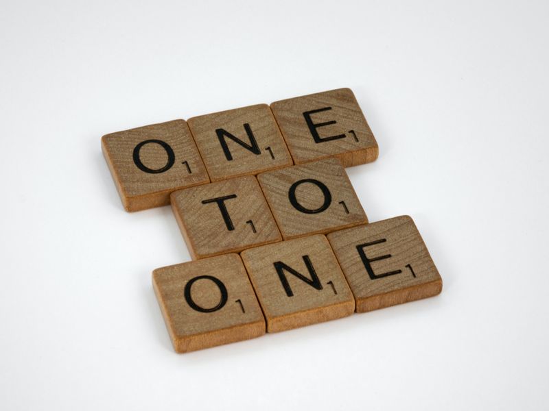 Scrabble tiles spell the words 'One,' 'To', and 'One'