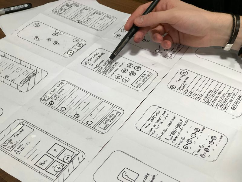 A person sketching out wireframes for a mobile app for customer interactions.