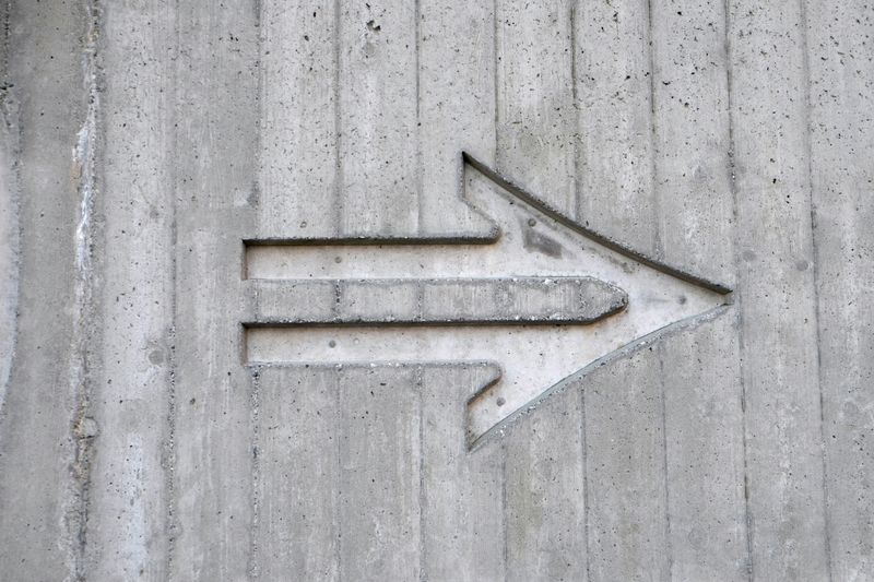 An arrow pointing to the right on a concrete wall.