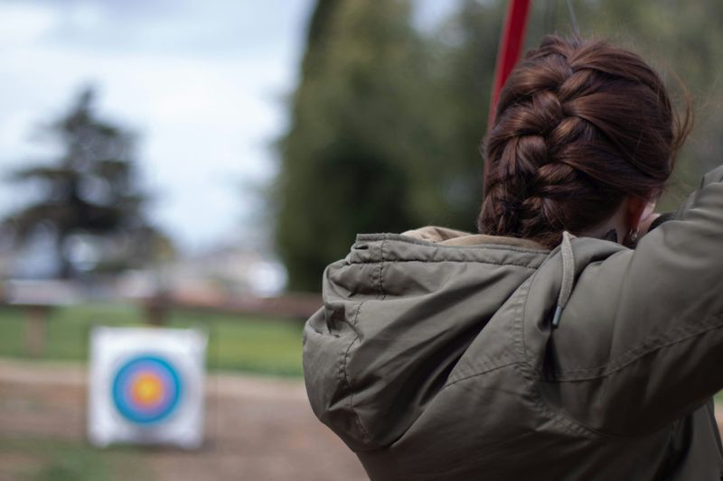 An archer aiming at the bull's eye of a distant target.