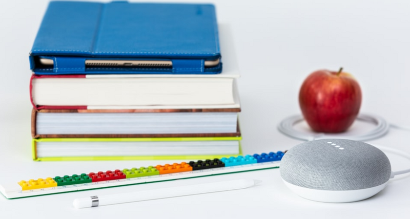 Books, an apple, and a mouse on a table