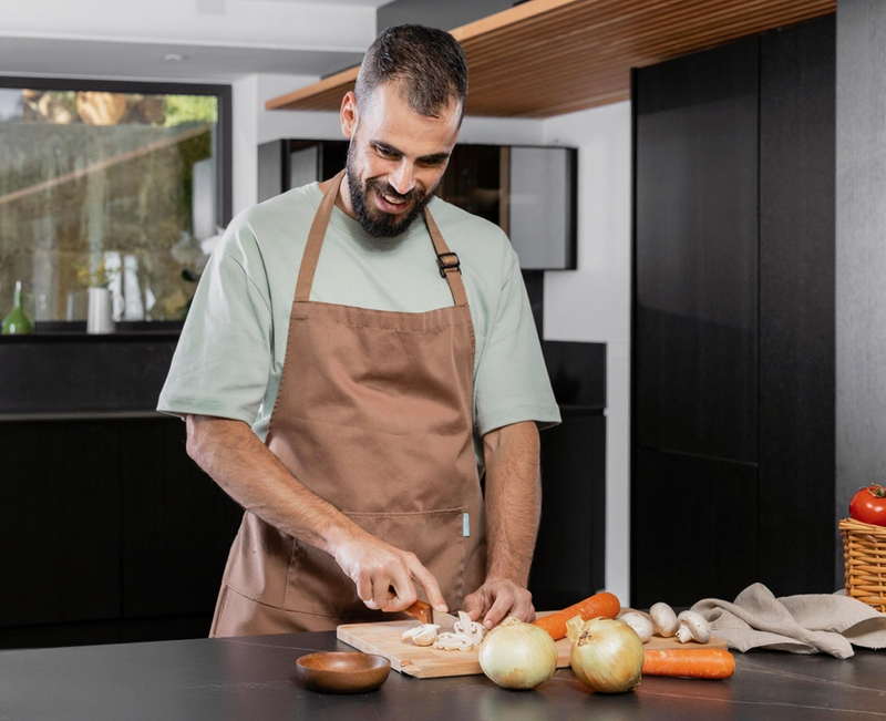 A person cutting vegetables in his home kitchen.