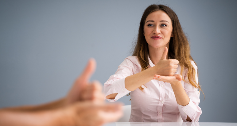 An aide communicates with a person through sign language.