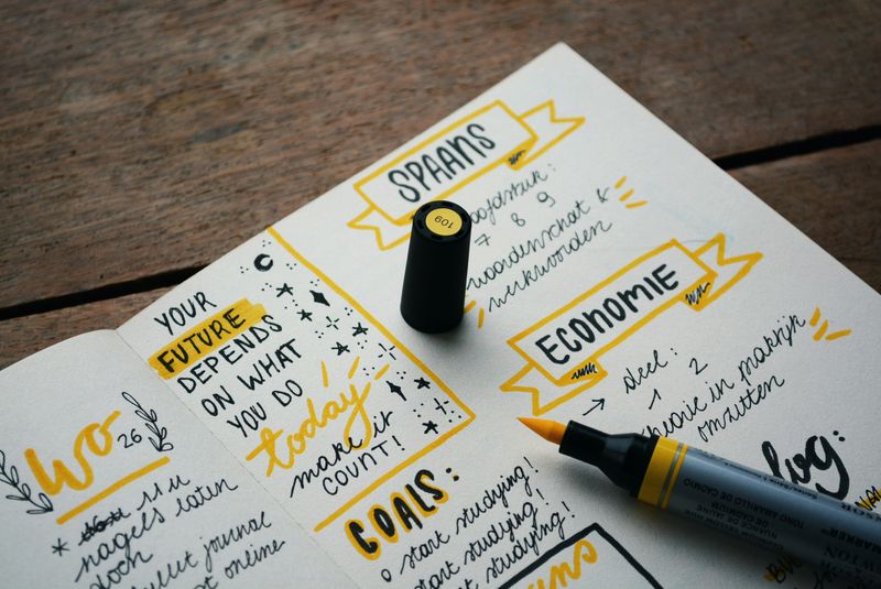 A planner with goals, dates and a yellow marker on an open page. 