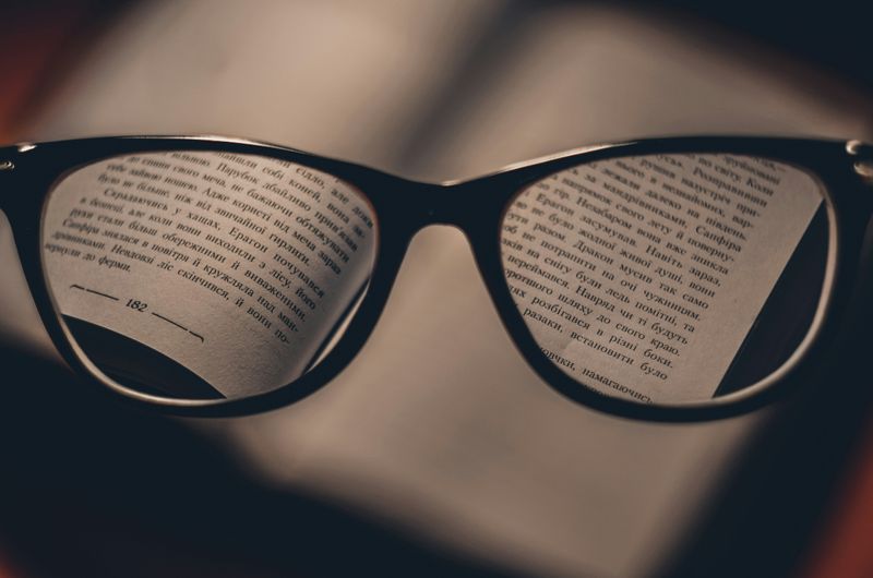 A view of a book through a pair of glasses.