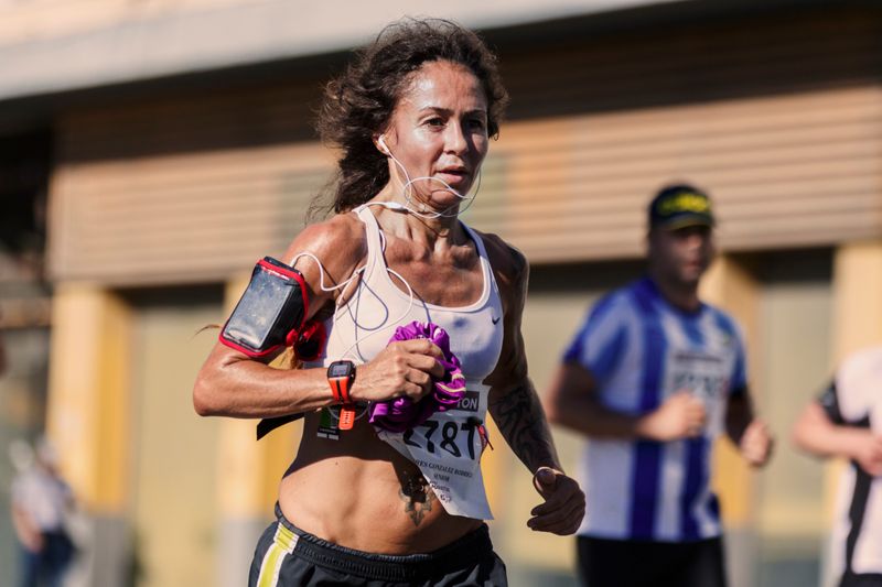 Image of a female runner in motion who is wearing running friendly gear.