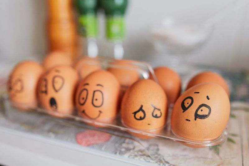 A carton of eggs carry a different facial expression drawn on each, ranging from surprise, happiness, and confusion.