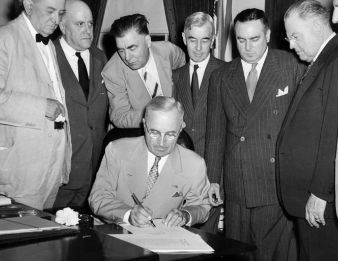 President Harry S. Truman signs the Atomic Energy Act.