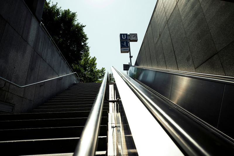 Upward view of outdoor subway entrance with stairs and escalator