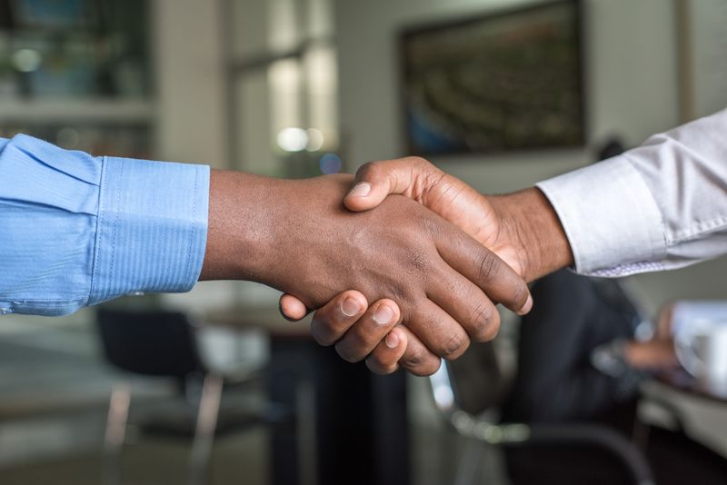 Two people shaking hands in an office