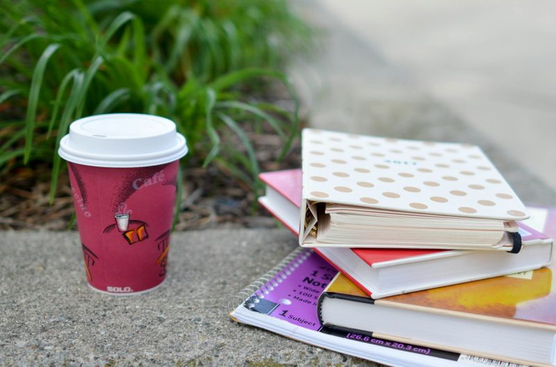 Stack of books with a coffee cup beside them