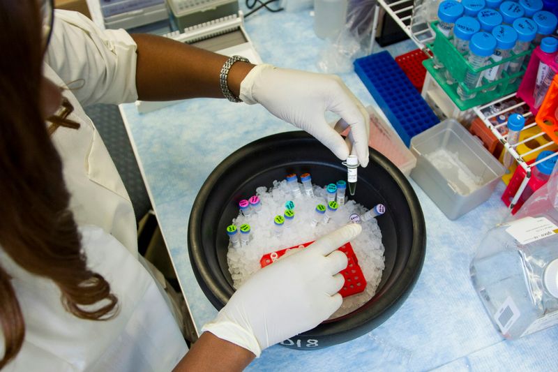 A lab technician working with pipette tubes. 