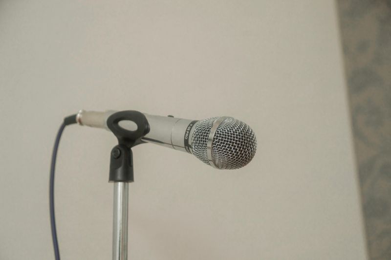 A handheld wired microphone in a stand.