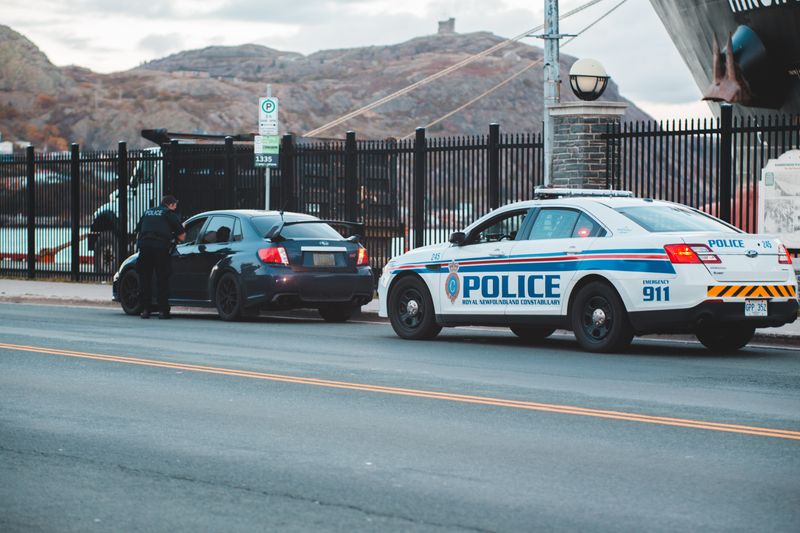 A police car pulling over a driver at the side of the road