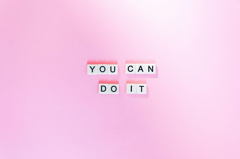 The words "You can do it" spelled in Scrabble letters on pink background