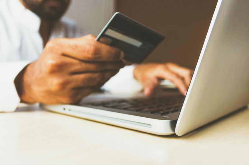 A man typing in his debit card number into a website.