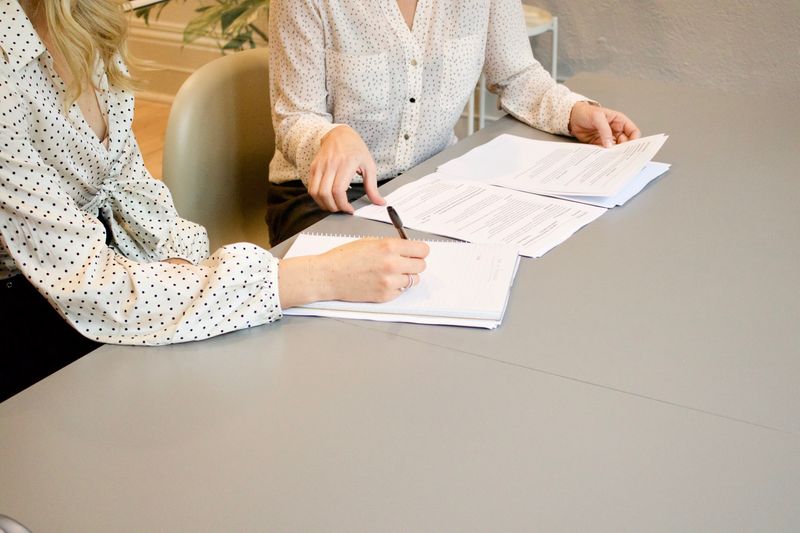 2 women sitting a desk discussing a work project