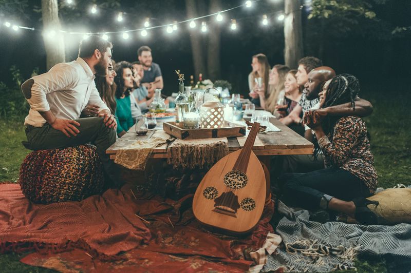 A group of people having a fun evening at an outdoor dinner party.