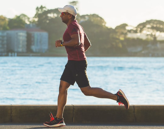 Man jogging during the day by the lake.