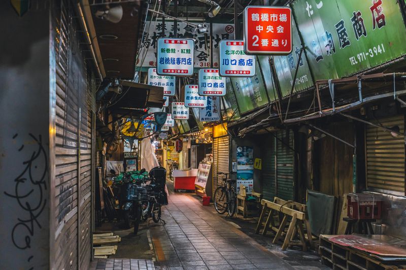 A Japanese street with lots of kanji on street and shop signs.