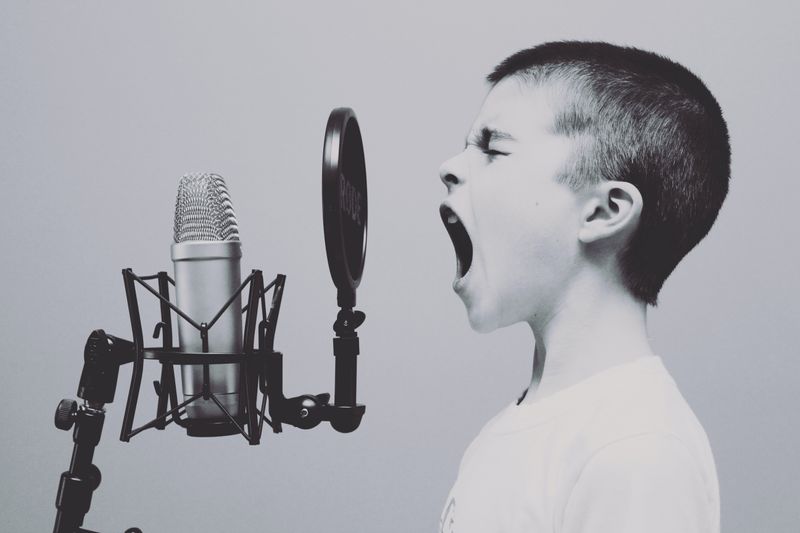 Boy speaking loudly into microphone