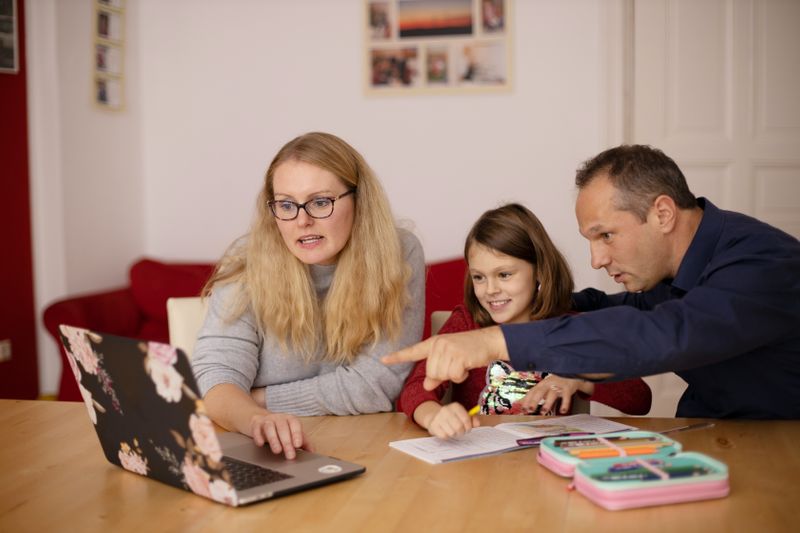 A woman, man and child looking at a computer screen.