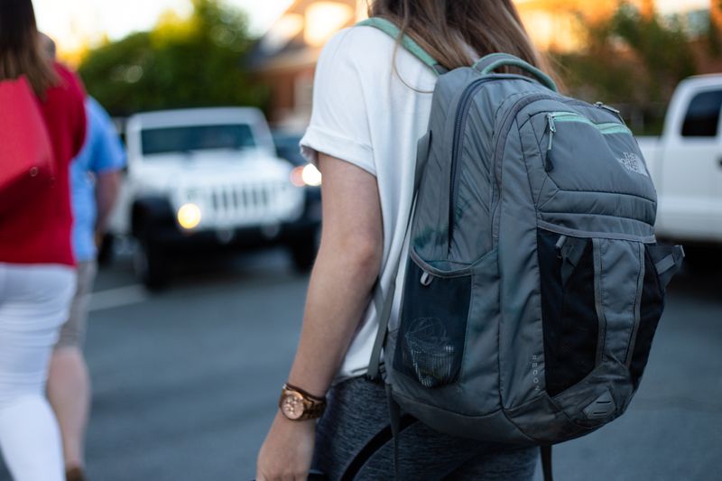 A student heading to school with their backpack on their shoulders.