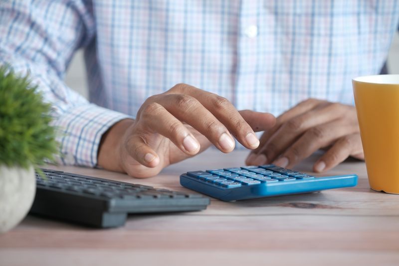 A person typing on calculators.