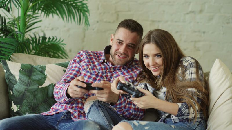 A young man and woman playing video games together.