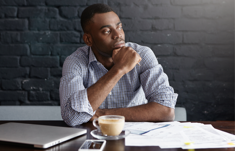 Businessman having a coffee at a cafe and thinking