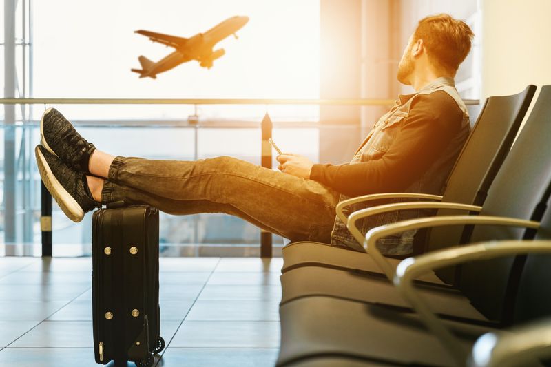 man in an airport looking out the window