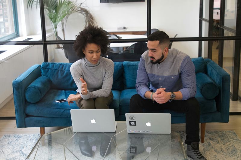 Two people having a conversation at an office about types of harassment.