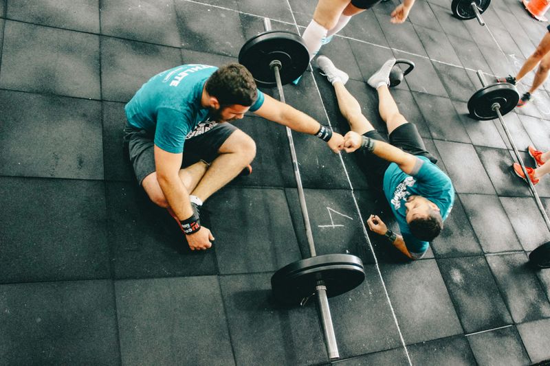 Two men bumping fists at the gym.