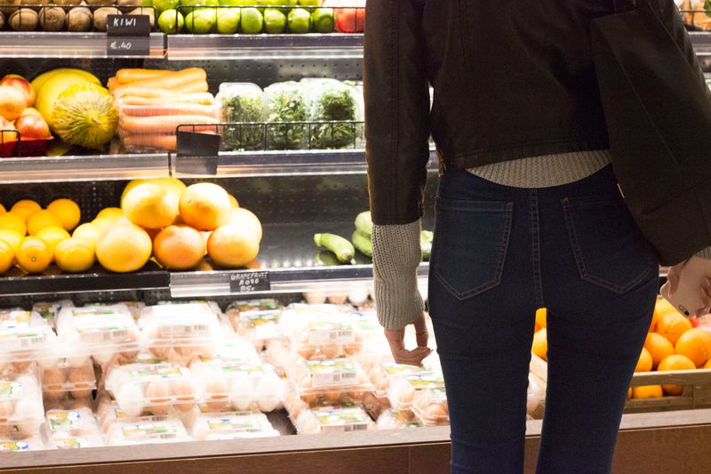 Woman standing in front of food refrigerator