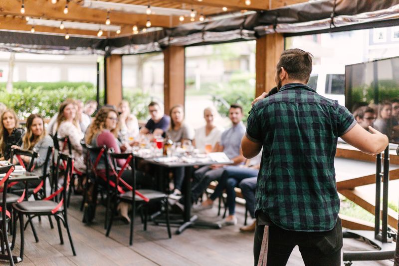 In a casual situation, a man is shown speaking to a group of listeners.