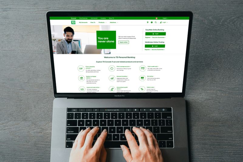 A person looking at a bank's website on a laptop.