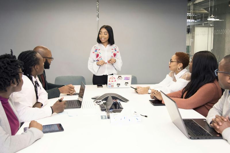 A woman standing talking to a team of people in a meeting room