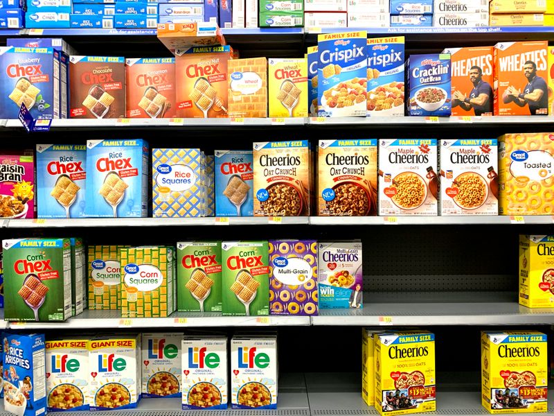 A grocery store shelf displaying different types of cereal boxes.