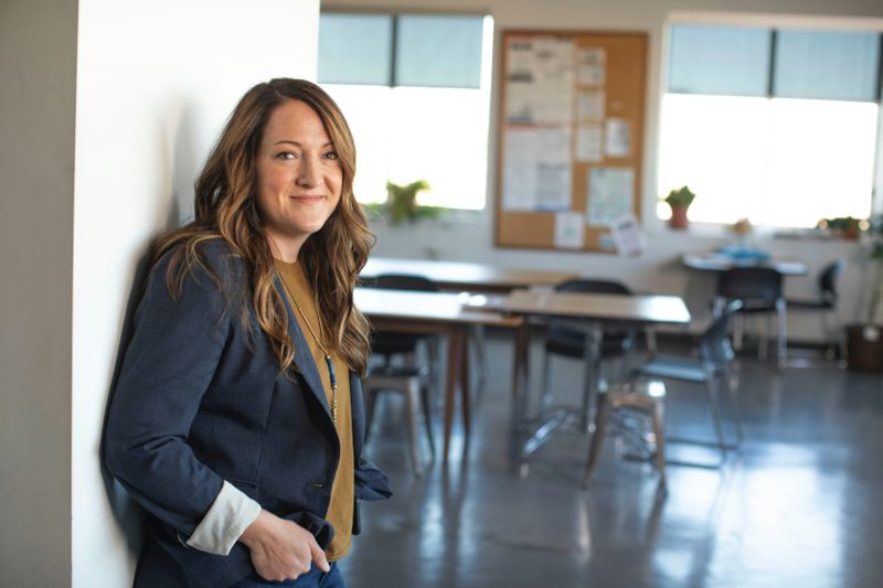 A principal standing next to a classroom.