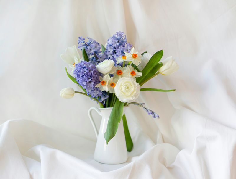 vase of purple, white and orange flowers