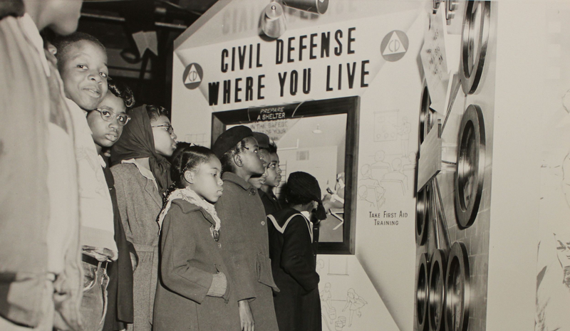 Children looking at a Civil Defense demonstration exhibit.