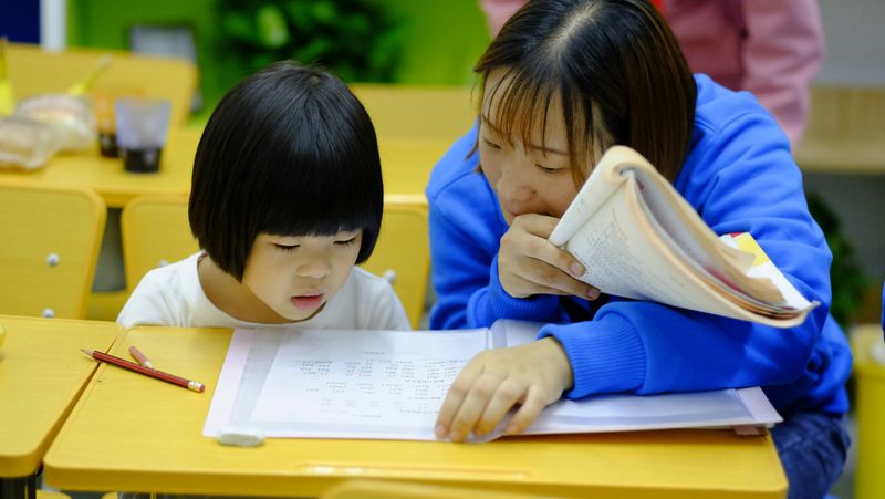 Teacher and student looking a work. 