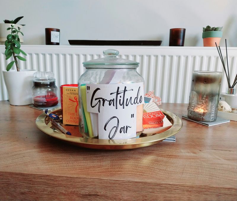 A gratitude jar filled with notes sitting on a table.