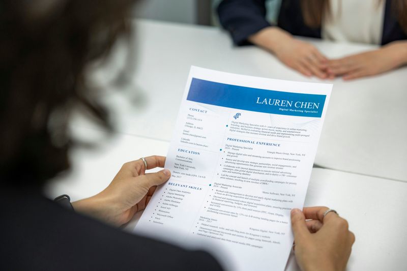 A hiring manager holding a person named Lauren Chen's resume.