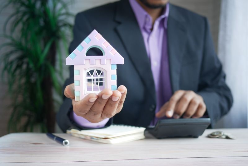 A loan officer at a desk holding a tiny house model