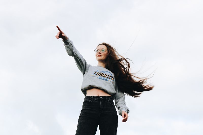 A woman wearing points off into the distance