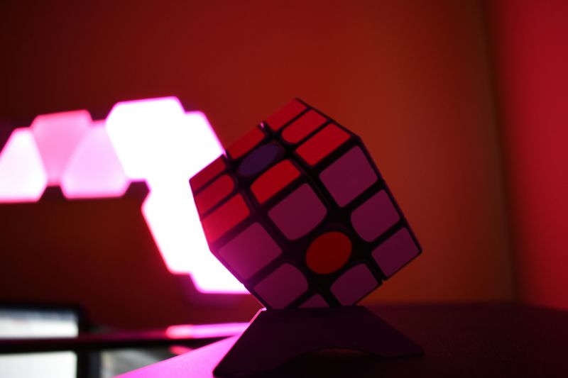 A Rubik's Cube in a room lit by purple LEDs.
