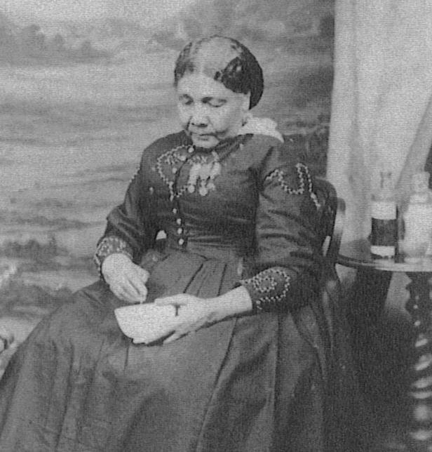 An original black and white photograph of Mary Seacole wearing a Victorian style dress and holding a bowl. 